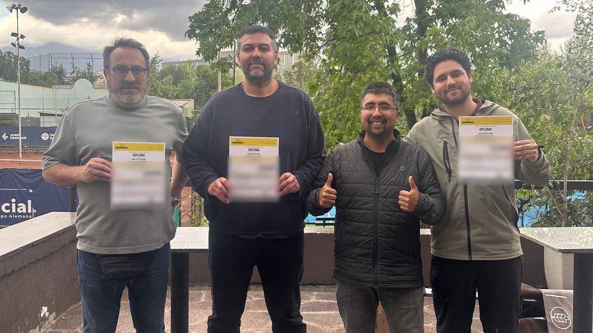 Los tres funcionarios de la Municipalidad de Estación Central con su diploma de AÉREO, junto al instructor, en el Stade Français