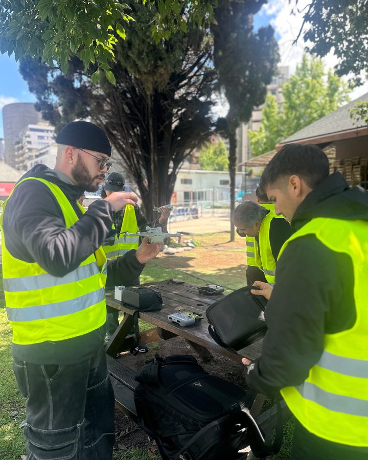 El instructor muestra el dron de cerca a un alumno del curso