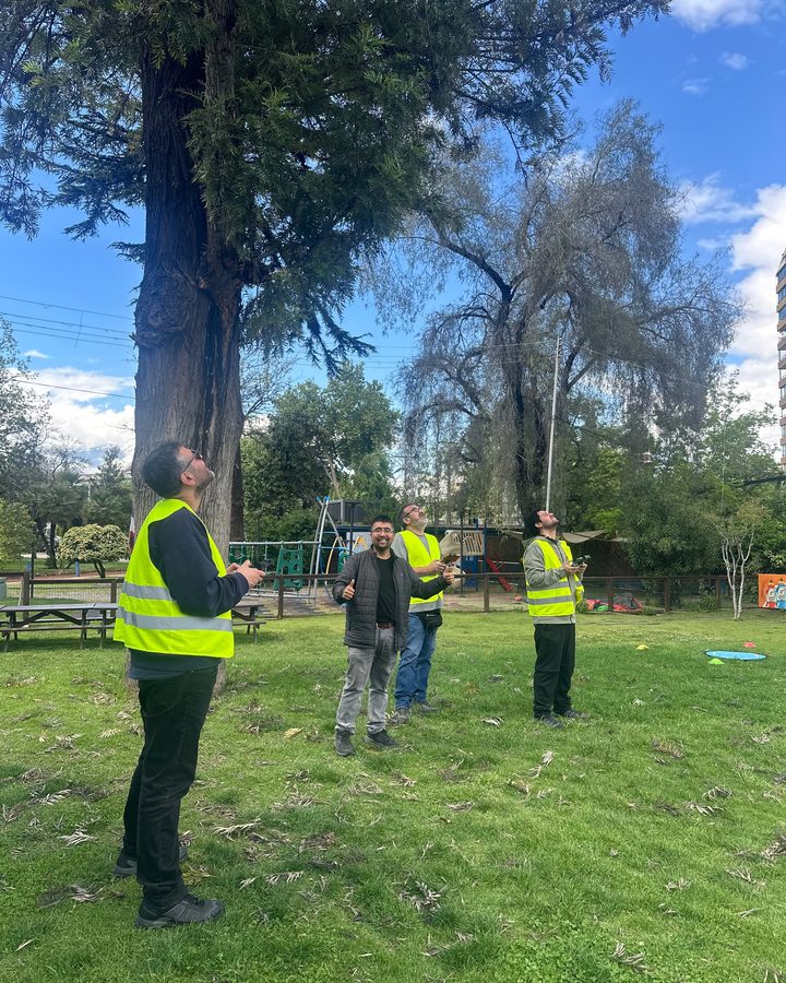 Cuatro alumnos con su propio mando siguiendo el dron en vuelo
