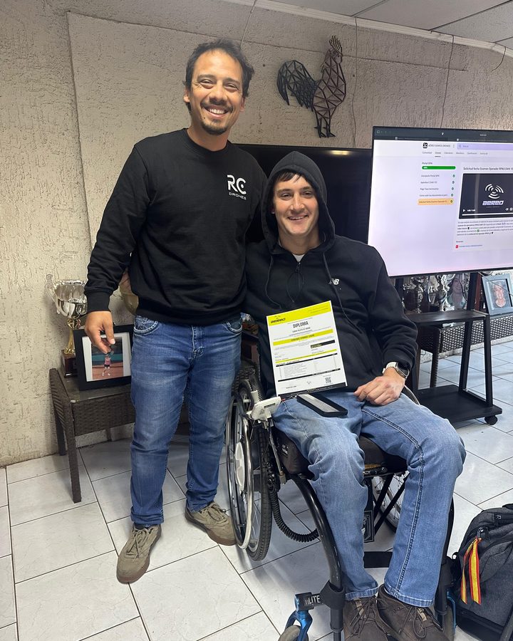 Alumno con su diploma del Curso Piloto de Drones junto al instructor