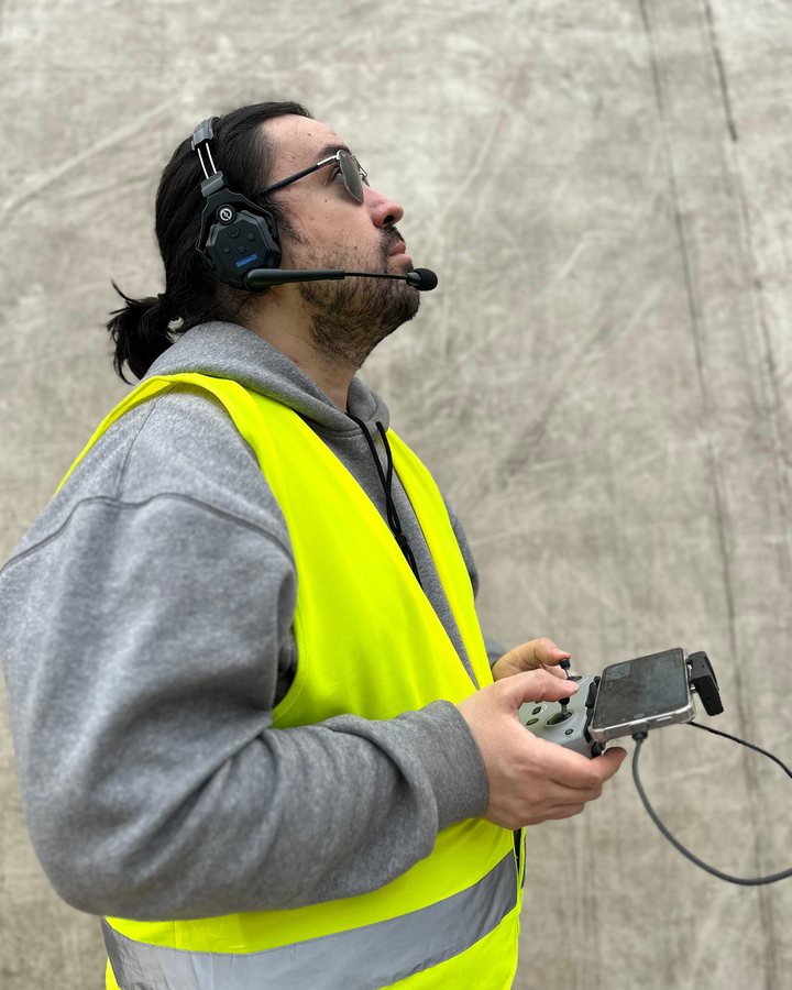 Alumno de AÉREO volando junto al domo, con headset y chaleco reflectante
