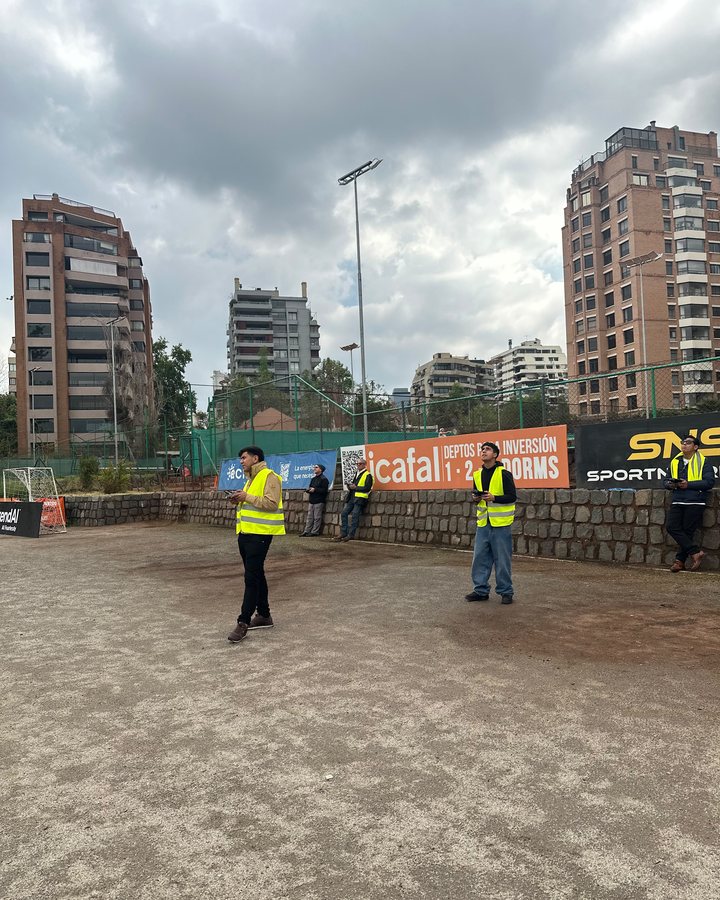 Grupo de alumnos practicando en la cancha, cada uno con su propio dron