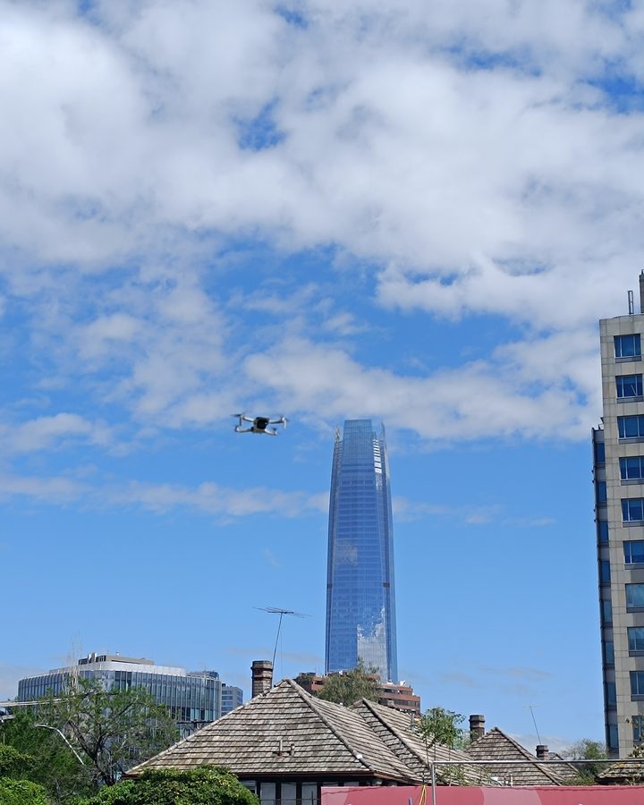 Dron en vuelo sobre la cancha de práctica, con la ciudad al fondo