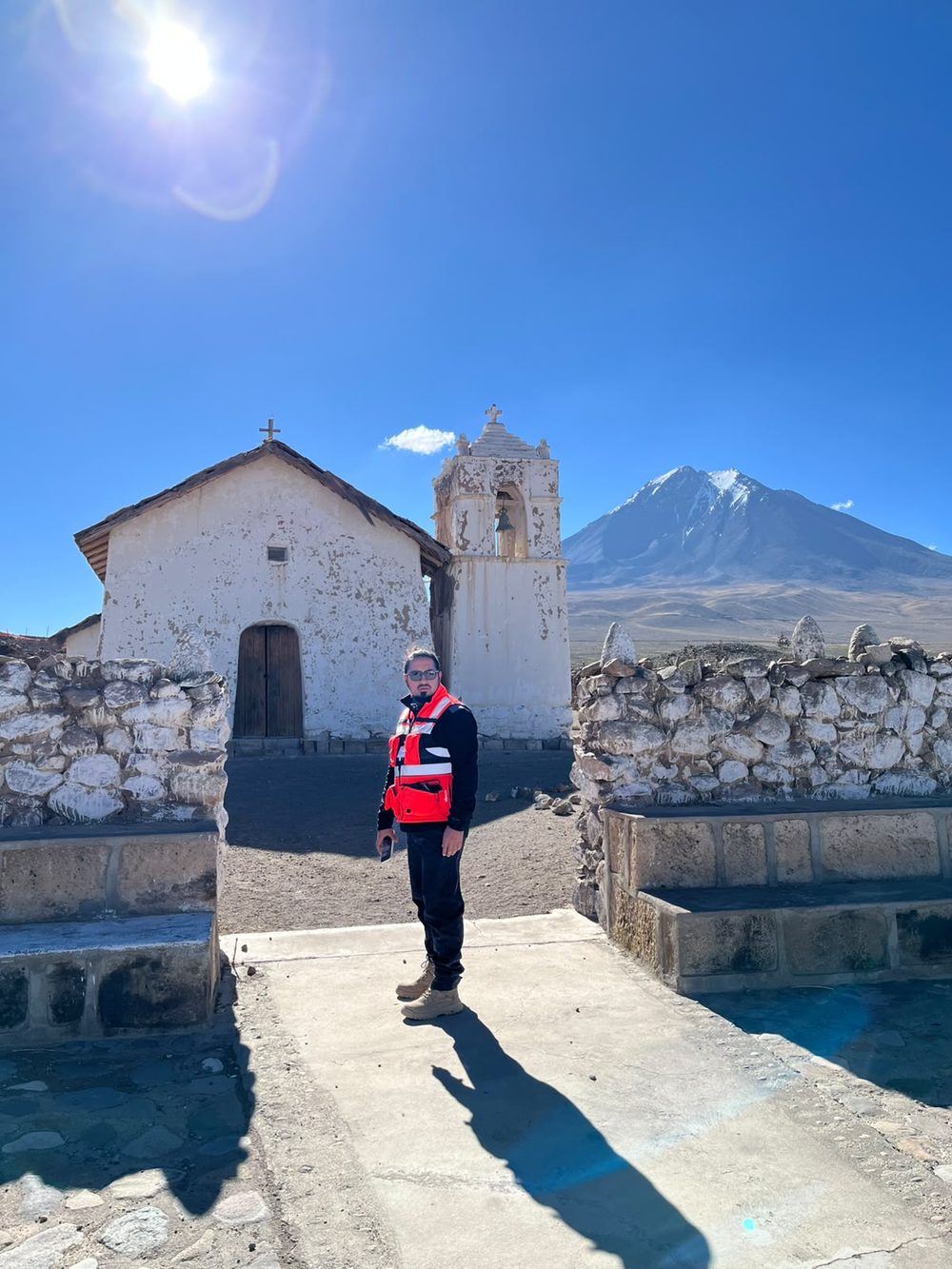 Iglesia de adobe del altiplano con un volcán nevado al fondo